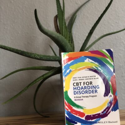 A book sitting on top of a table next to a plant.