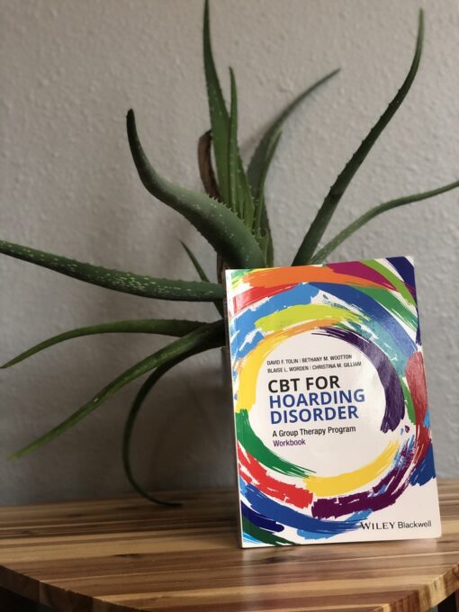 A book sitting on top of a table next to a plant.